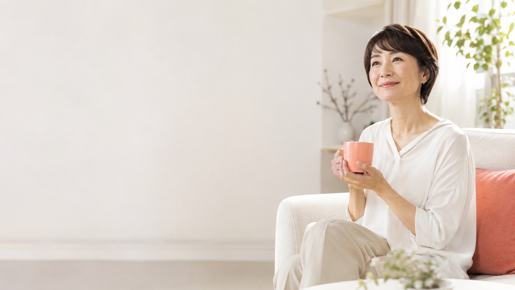 あたたかい飲み物とひざ掛けでくつろぐ女性
