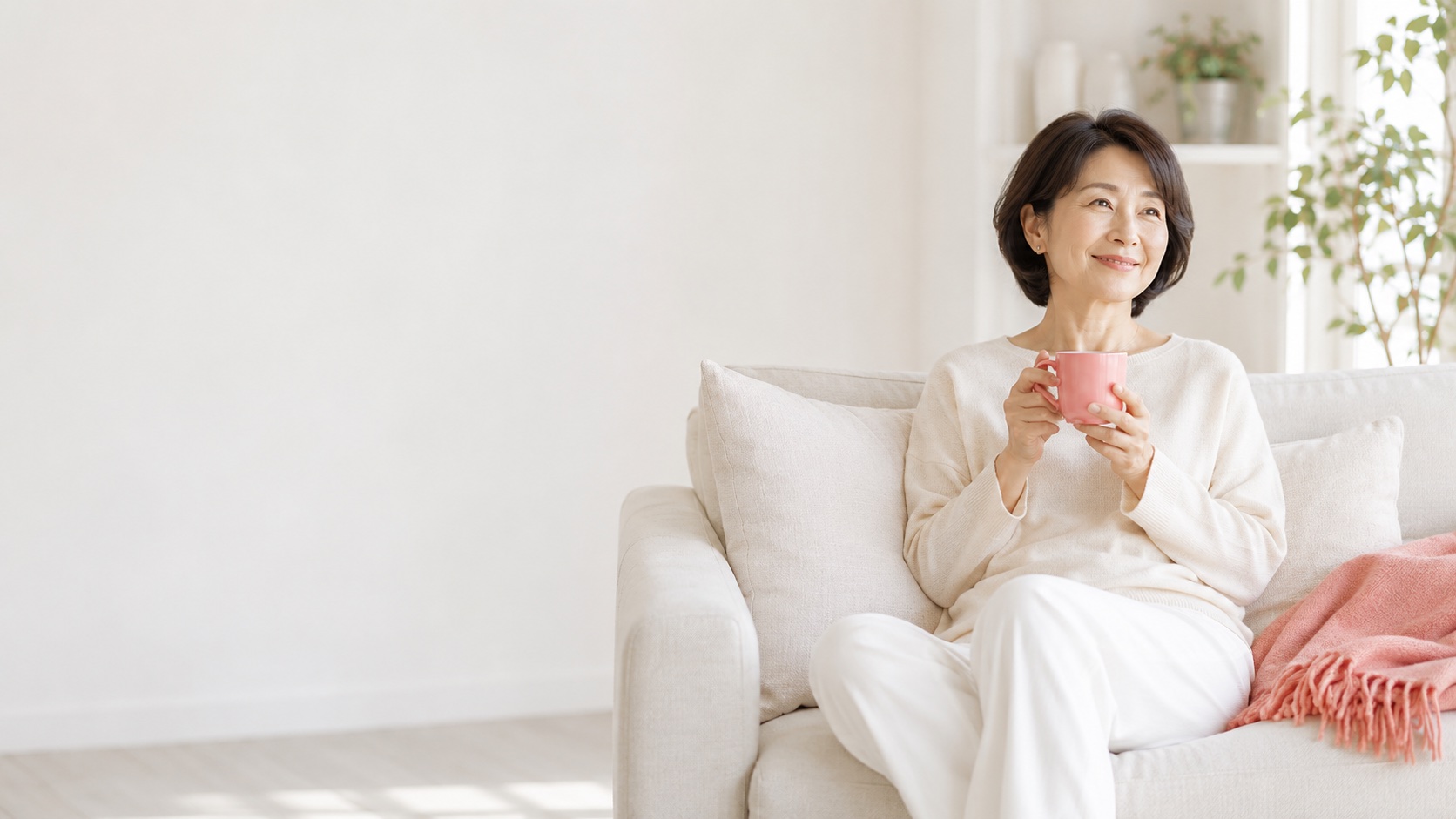 ソファでくつろいでお茶を飲む女性