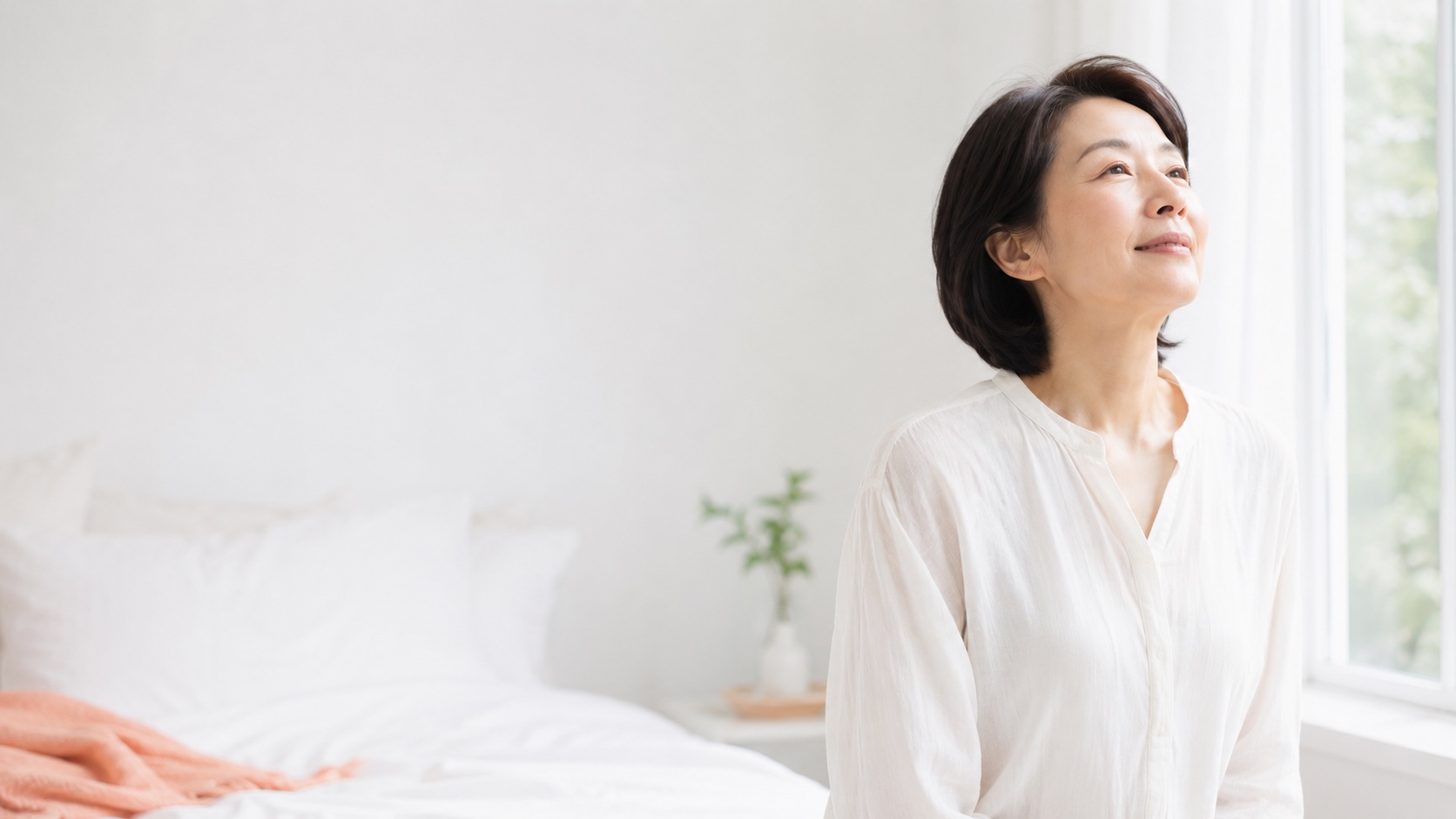 窓辺で深呼吸する・すっきり目覚めた女性